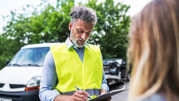 agente de seguros preenchendo planilha em meio a um local de acidente