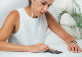 mulher mexendo no celular com semblante tenso