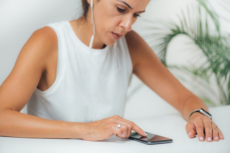 mulher mexendo no celular com semblante tenso