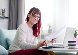 mulher sorridente calculando suas finanças