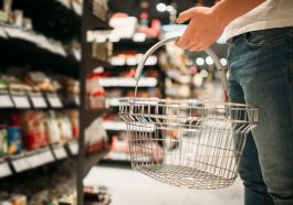 homem com cesta de compras vazia na mão olhando para a prateleira no supermercado