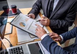 homens de negócios discutindo planilha de resultados