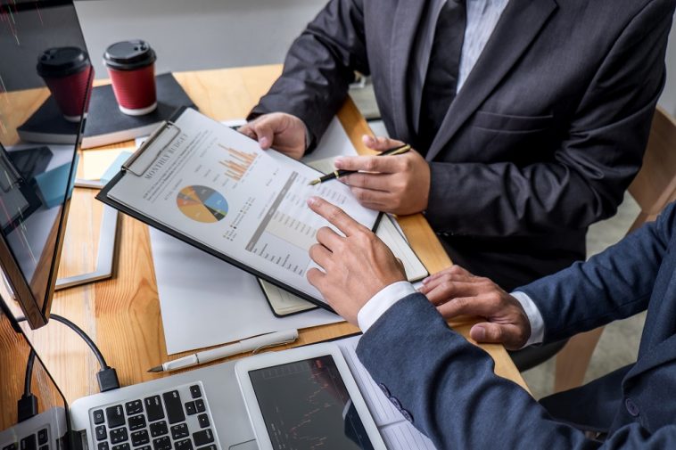 homens de negócios discutindo planilha de resultados