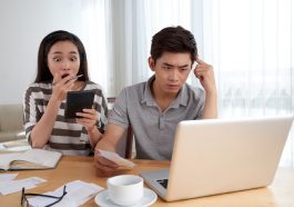 casal jovem espantado com suas finanças e dívidas