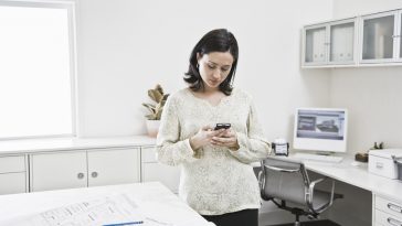 Mulher hispânica trabalhando no telefone celular