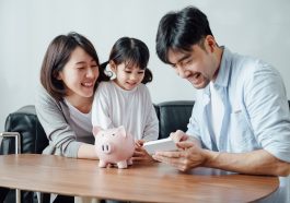 Pais ensinando filha para economizar dinheiro em casa