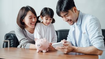 Pais ensinando filha para economizar dinheiro em casa