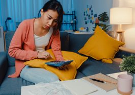 mulher asiática estressada calculando as taxas de juros de cartão de crédito e pensando em fazer um empréstimo
