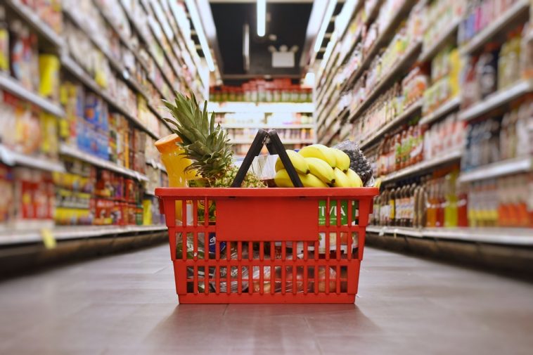 cesta básica com algumas frutas no chão de um supermercado, simbolizando o preço da cesta básica em BH