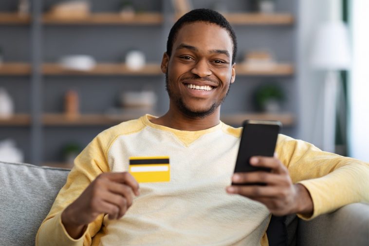 Homem afro-americano alegre com cartão de crédito sem anuidade