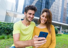 Casal uso do celular em conjunto para ver o calendário da segunda parcela do auxílio emergencial 2021 atualizado