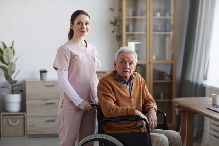 Retrato de jovem enfermeira e homem sênior em cadeira de rodas demonstrando a necessidade no aumento da aposentadoria por invalidez