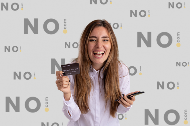 mulher sorrindo segurando um cartão de crédito para negativado