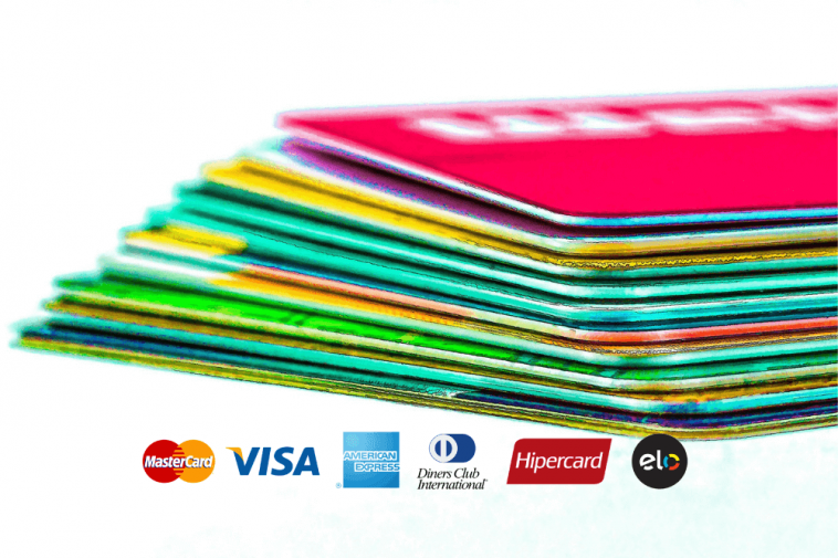 cartões de crédito empilhados ao fundo e mais a frente algumas bandeiras de cartão de crédito