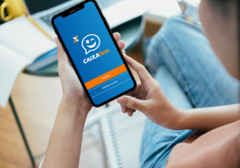 mulher acessando o aplicativo Caixa Tem no celular para conferir sobre o auxílio emergencial será prorrogado