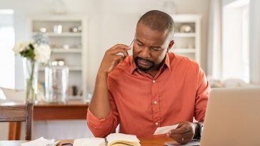 Homem preocupado com contas chamar o banco para entender o open banking o que é e como funciona