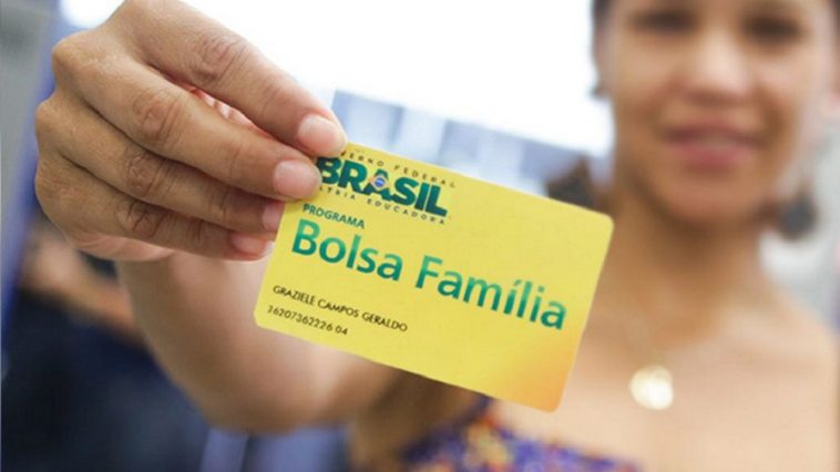 mulher segurando um cartão do novo Bolsa Família