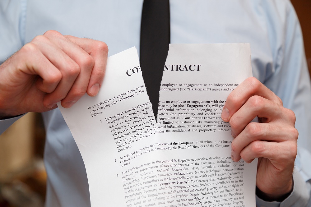 homem rasgando um contrato simbolizando como cancelar um empréstimo