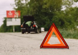 Carro com problemas e um triângulo vermelho para avisar outros usuários da estrada