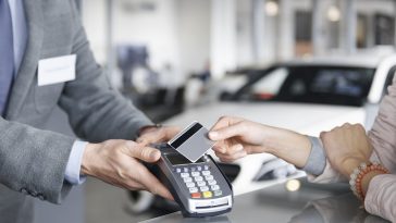 Close-up do pagamento com cartão, simbolizando como comprar carro com cartão de crédito