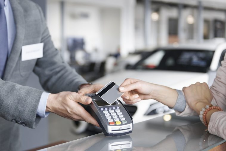 Close-up do pagamento com cartão, simbolizando como comprar carro com cartão de crédito