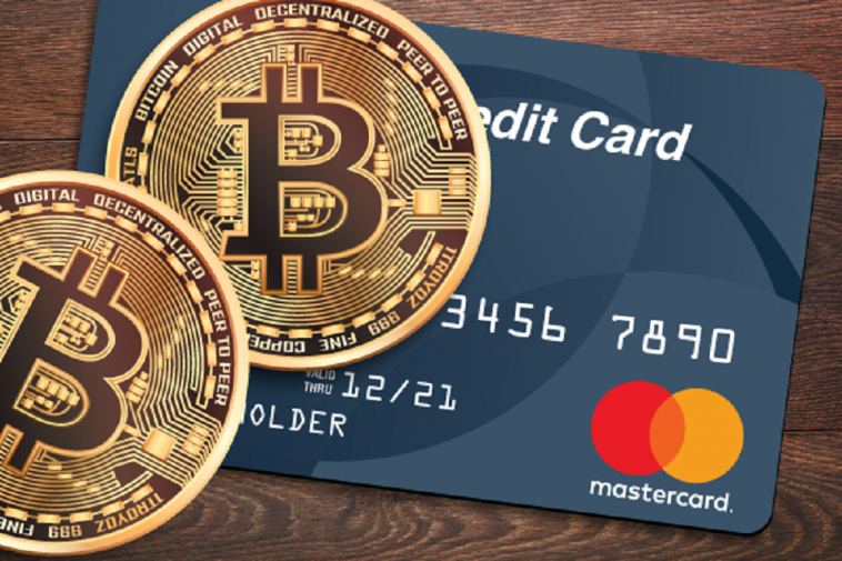 imagem de cartão de crédito da bandeira Mastercard e em cima dele uma moeda de Bitcoin, simbolizando o primeiro cartão de crédito com limite de crédito em criptomoedas