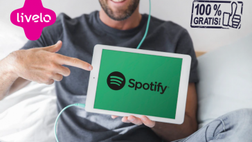 Homem jovem segurando tablet escutando spotify de graça com a Livelo