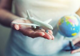 Mãos de mulher feminina segurando um avião modelo de brinquedo pequeno e mapa do globo viajar de avião férias fim de semana aventura