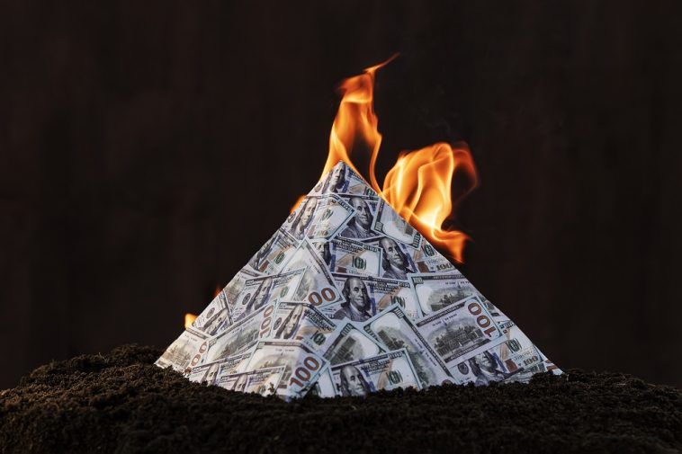 pirâmide no formato de dinheiro e no topo queimando, simbolizando o golpe