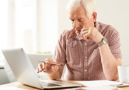 homem idoso mexendo no computador, simbolizando a entrada da aposentadoria