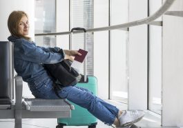 Vista lateral da pessoa segurando o passaporte médico no aeroporto, simulando como ir trabalhar no exterior